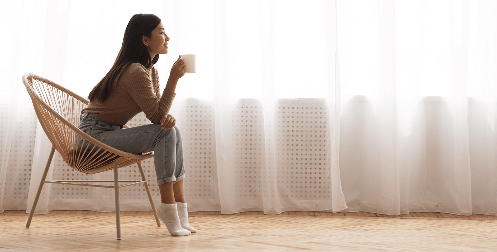 Woman drinking tea in serene beige backlit room
